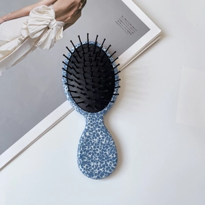 Portable acetate hair brush with blue floral pattern and black massage bristles