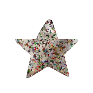 Pinza per capelli a stella in acetato con paillettes olografiche su sfondo bianco