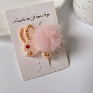 Dettaglio fermaglio per capelli a coniglio rosa con pompon di peluche, strass e perle