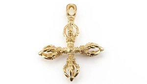 Detalle macro de un colgante de cruz Vajra dorado con intrincados grabados religiosos