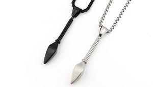Close-up of matte black and silver spearhead pendants with textured handle details