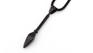 Macro shot of a black stainless steel spearhead pendant on a high-quality box chain