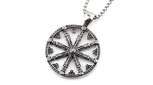 Primer plano del colgante rueda del dharma en plata antigua con grabados y circonitas
