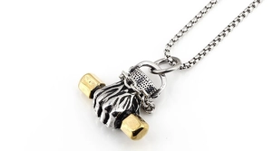 Macro detail of bicolored silver and gold fist pendant with dumbbell on box chain