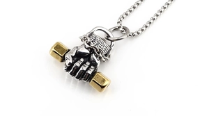 Macro close-up of hiphop silver fist holding golden dumbbell pendant on thick chain