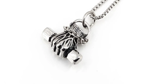 Detailed close-up of retro silver fist and dumbbell pendant with vintage steel finish