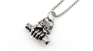 Macro shot of vintage steel fist holding dumbbell pendant with oxidized muscle textures