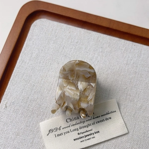 Détail d'une pince à cheveux en acétate marbré avec gravure faite main en France