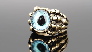 Macro shot of gothic evil eye ring with blue stone and bronze claw details