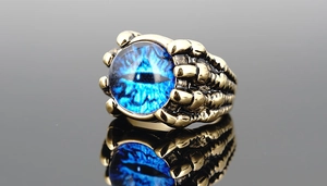 Detailed close-up of a blue evil eye ring with retro gold-tone dragon claw setting
