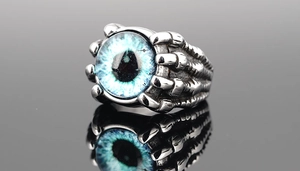 Macro detail of gothic dragon claw ring holding a realistic blue evil eye stone