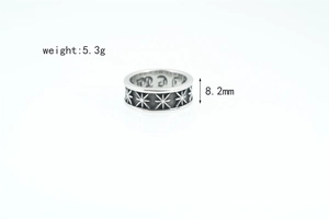 Macro shot of silver punk ring featuring black octagonal star patterns and gothic engraving