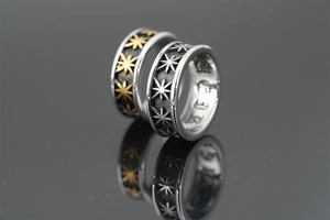 Macro shot of silver and gold punk steel rings with embossed hexagram star pattern