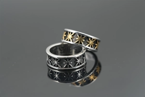 Macro detail of punk star pattern engraving on polished stainless steel rings
