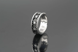 Detailed view of silver titanium steel ring with engraved star pattern and inner engraving