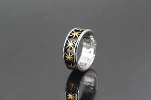 Macro view of vintage punk titanium steel ring with black texture and golden star engraving