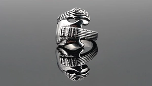 Macro shot of vintage guitar shaped punk ring in distressed titanium steel with mirror effect