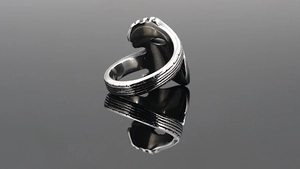 Detailed close-up of retro titanium steel ring with carved 3D helmet and ribbed texture