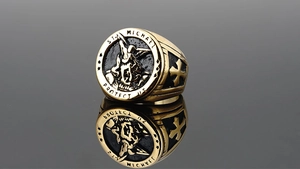 Detailed close-up of golden St. Michael signet ring with vintage engraving and shield design