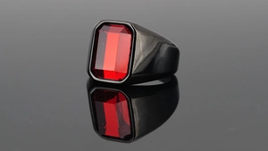 Détail d'une bague pour homme en acier titane avec serti noir et pierre rouge carrée