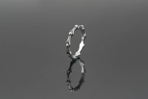 Macro view of vintage bamboo joint ring in titanium steel on black reflective surface