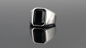 Gros plan sur bague chevalière pour hommes avec pierre noire rectangulaire et argent