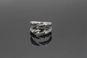 Macro shot of silver punk ring with detailed double eagle claw texture and scales