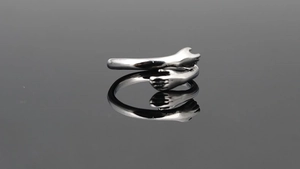 Macro shot of polished silver hug ring showing detailed hand-shaped embracing arms