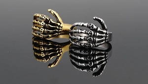 Makroaufnahme von Punk-Skeletthandring in Gold und Silber mit detaillierten Totenköpfen