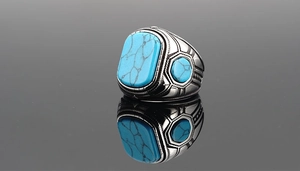 Vista macro de anillo vintage de acero titanio con piedra turquesa y grabados detallados