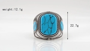 Detalle macro de anillo vintage con turquesa azul y grabados florales en relieve