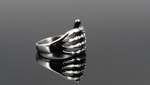 Detailansicht eines Punk-Skeletthand-Rings aus Vintage-Stahl mit Metallreflexionen