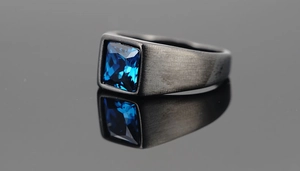 Macro view of men's square blue gemstone ring with brushed dark grey metal finish