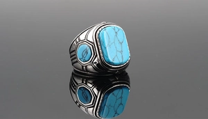 Primer plano de anillo vintage de acero de titanio con turquesa sobre fondo negro