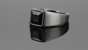 Macro view of matte black brushed titanium steel signet ring with square black gemstone