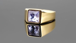 Detailed macro view of a gold-plated signet ring featuring a square lavender gemstone inlay
