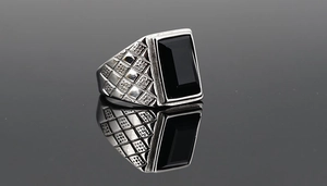 Detailed view of men's steel ring with black rectangular stone and textured sides