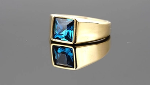 Macro shot of gold-plated signet ring with a square-cut deep blue sapphire stone