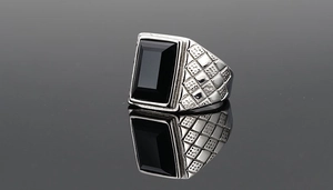 Macro shot of silver-toned stainless steel ring with a large rectangular black onyx gemstone