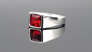Detailed view of silver titanium steel ring with square red ruby stone in bezel setting