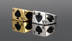 Makroaufnahme von Gold- und Silber-Pik-As-Ringen mit Vintage-Punk-Metalltextur