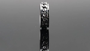 Macro shot of silver stainless steel rotating bottle opener ring with Cuban link chain detail