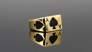 Detaillierte Nahaufnahme eines vergoldeten Ace of Spades Rings mit schwarzer Emaille