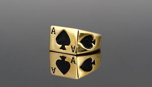 Detailaufnahme des goldenen Pik-As-Rings mit schwarzer Emaille auf glänzendem Grund