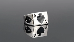 Makro-Detail von silbernem Poker-Ring mit Pik-As und schwarzer Emaille auf Spiegelreflexion