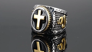 Macro detail of men's stainless steel cross ring with black enamel and vintage engraving