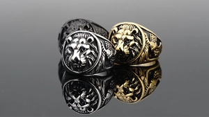 Detailed macro view of lion head rings in silver, gold, and black finishes with reflections