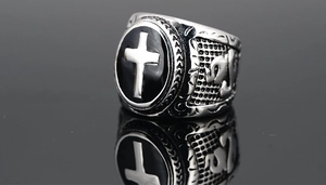 Macro detail of gothic stainless steel cross ring with black enamel inlay and engraved band