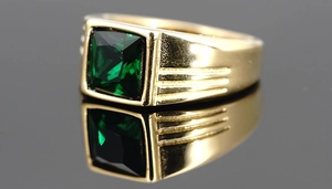 Makroaufnahme von Herrenring in Gold mit quadratischem grünem Edelstein und Streifendetails