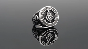Macro shot of Freemasonry seal ring in titanium steel with detailed G symbol engraving